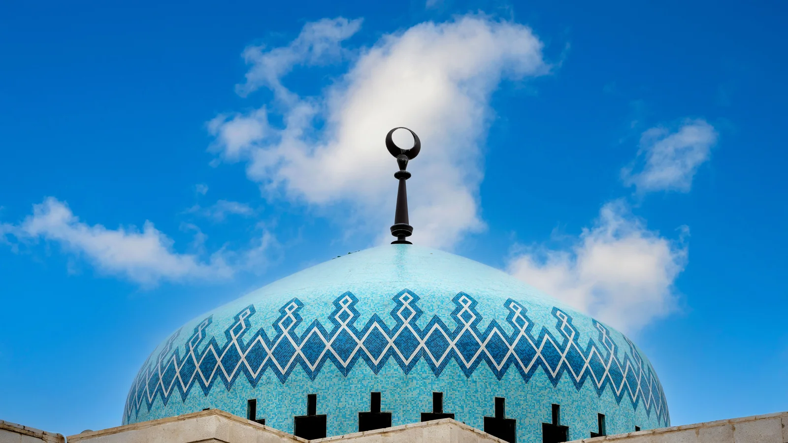 The blue patterned dome and crescent finial of King Abdullah I Mosque in Amman.