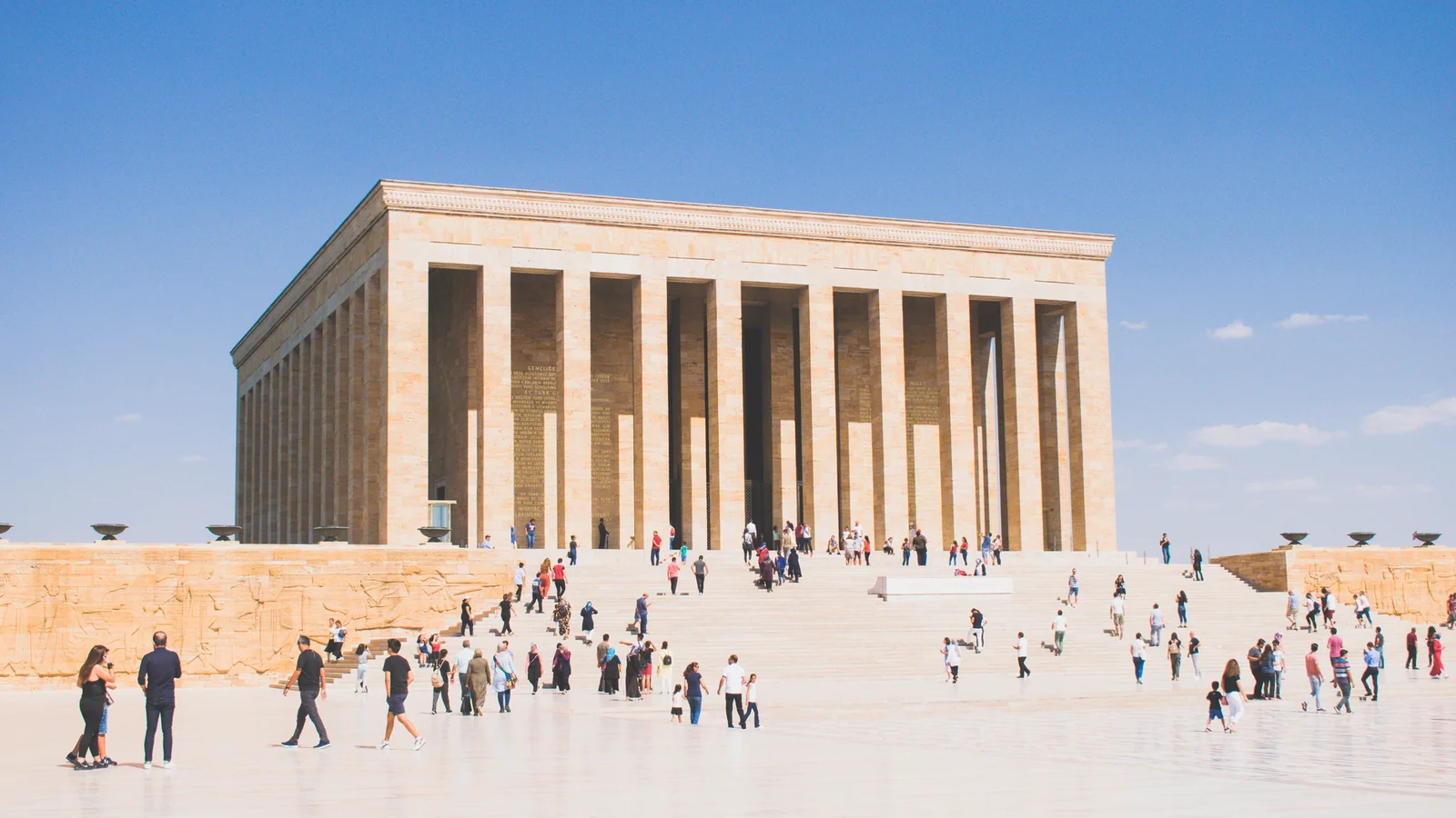 Visitors crossing Anıtkabir’s open courtyard toward the monumental columned mausoleum.