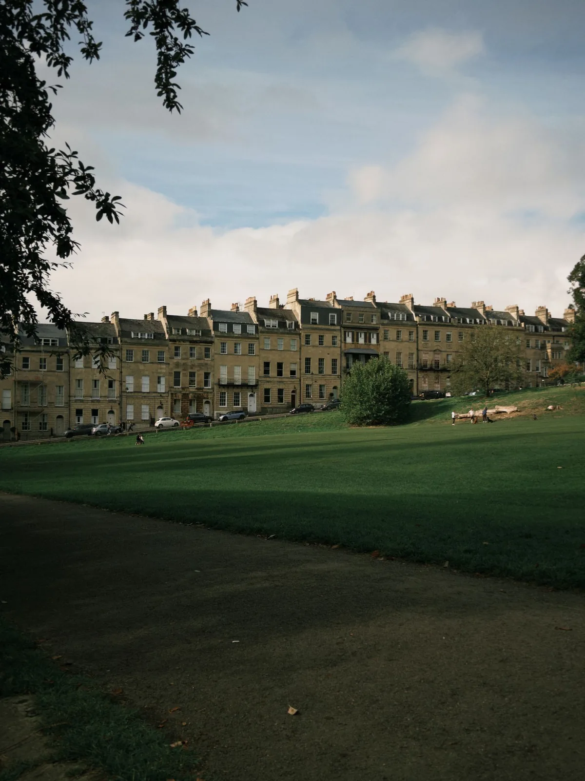 Georgian terraced houses beside a lawn in Bath