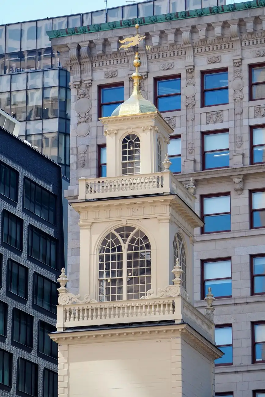 The Old State House’s white cupola and gilded banner weathervane against Boston’s later buildings