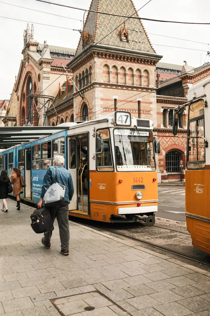 A tram numbered 47 in front of Budapest’s Great Market Hall and its tiled roof