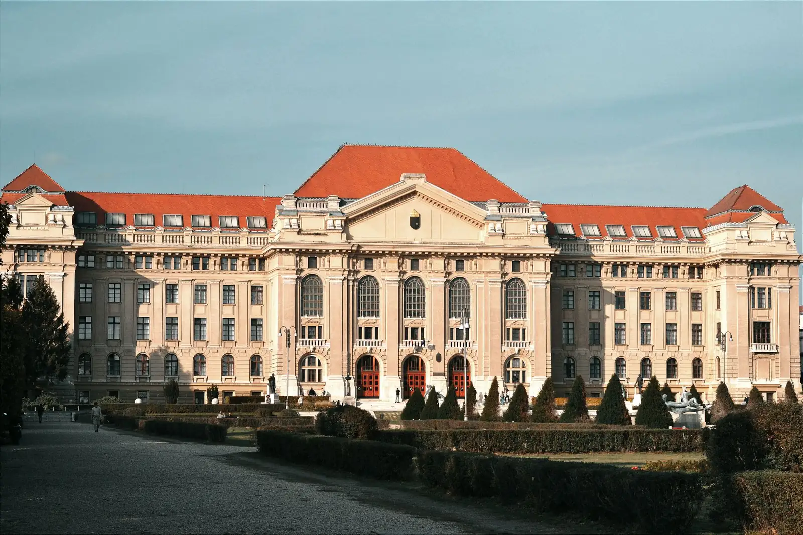 The red-roofed main building of the University of Debrecen beyond its formal forecourt