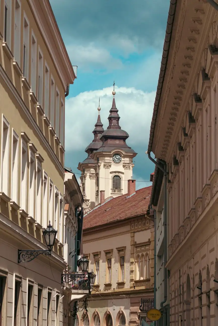 Eger’s historic Jókai Street framed by townhouses with the Minorite Church towers beyond