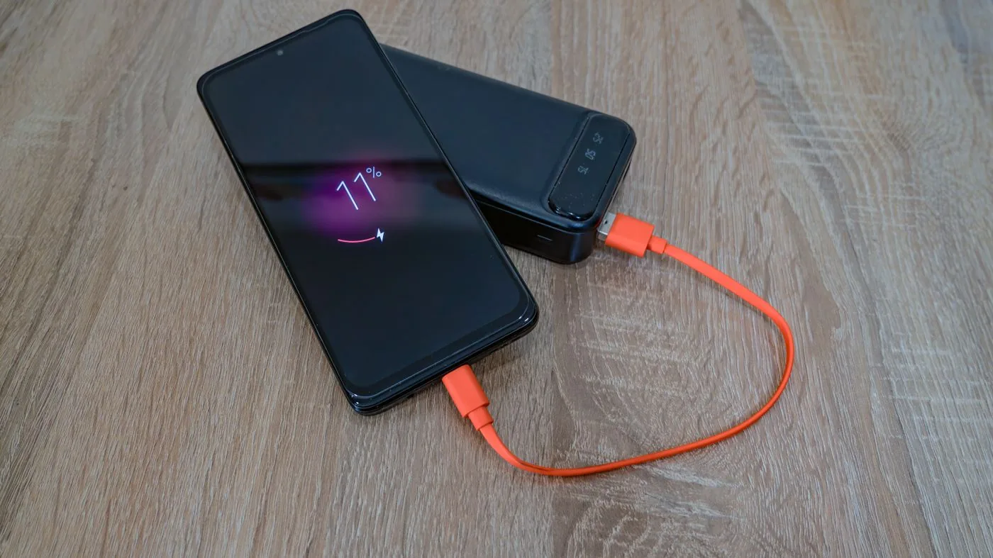 Phone connected to a portable power bank with a charging cable