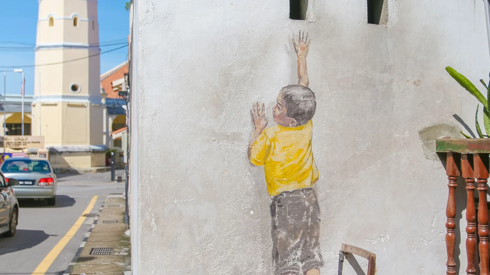 A detail of the painted child reaching towards a wall opening beside Acheen Street Mosque, George Town.