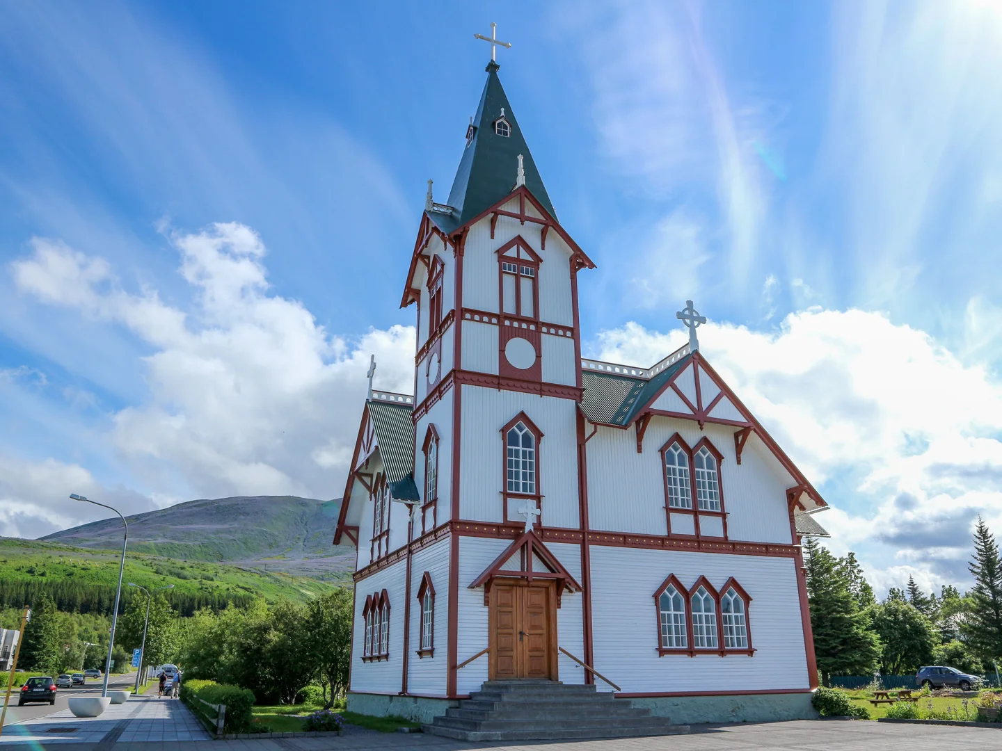 Húsavíkurkirkja with white timber walls, red trim and a pointed tower