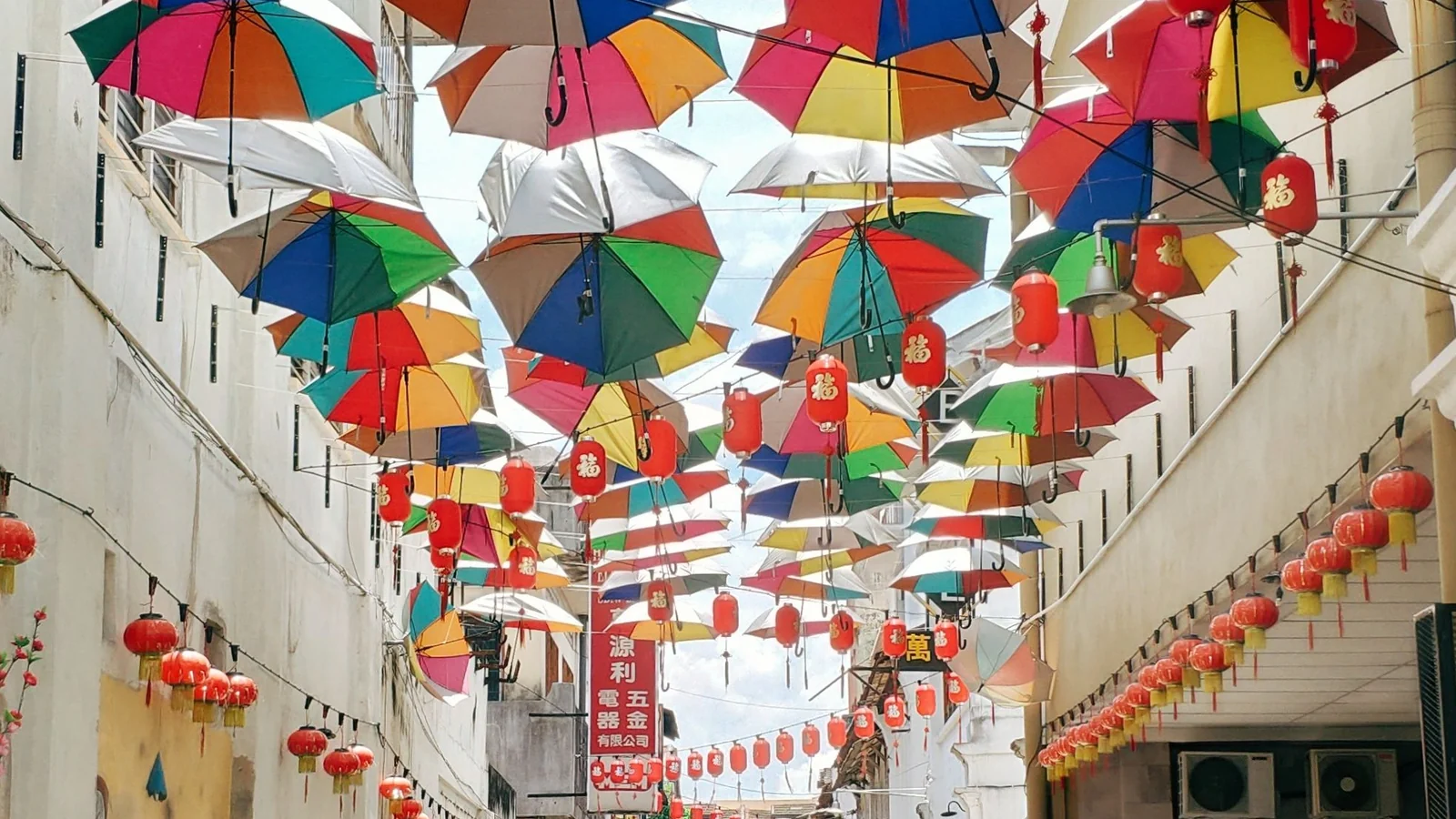 Colourful umbrellas and red lanterns suspended above Ipoh’s Market Lane.
