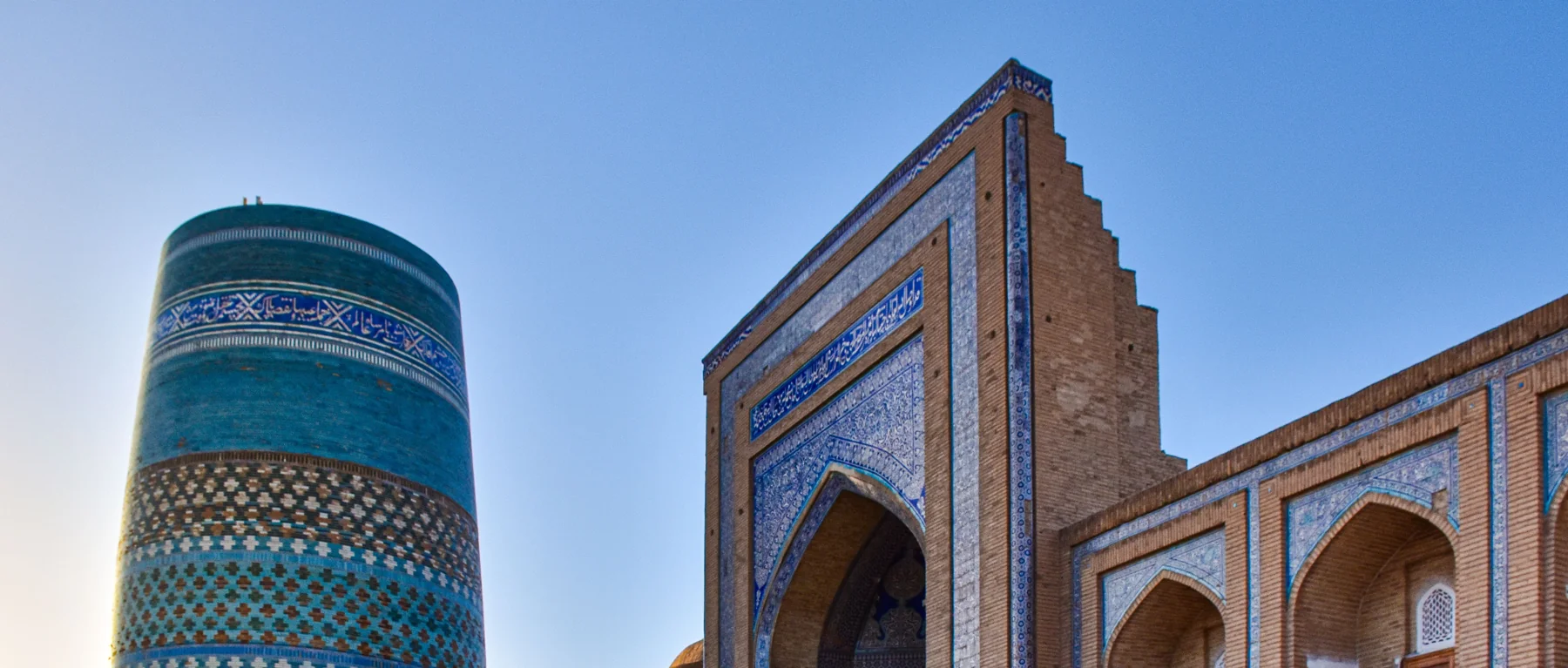 Turquoise tile bands of Kalta Minor beside the entrance portal of Muhammad Amin Khan Madrasah in Khiva