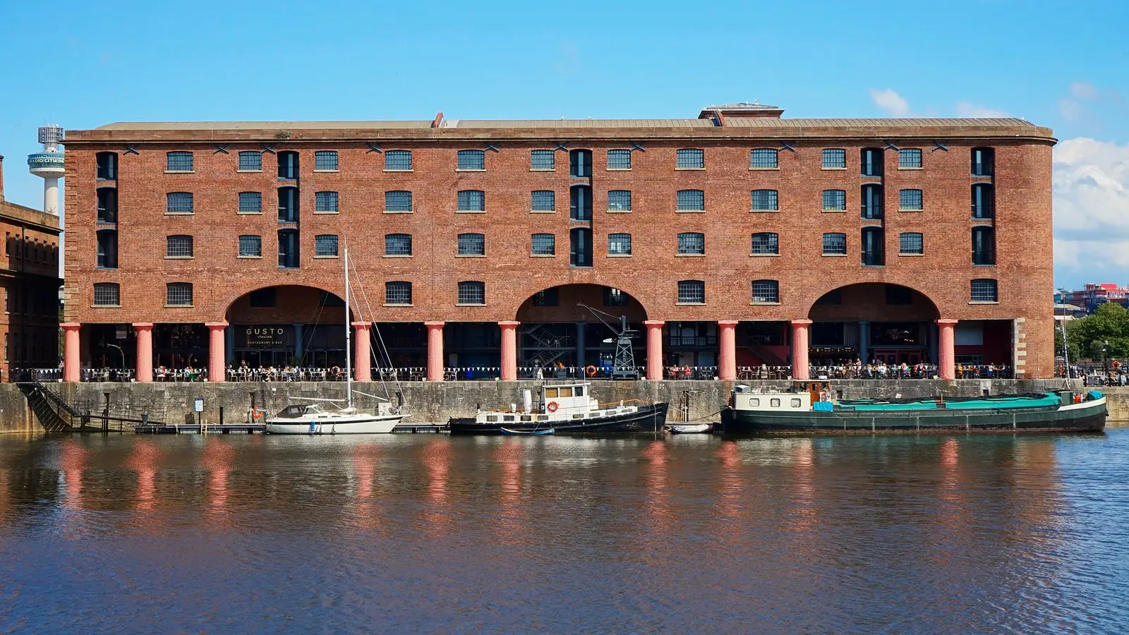 Brick warehouses reflected in Royal Albert Dock’s basin in Liverpool