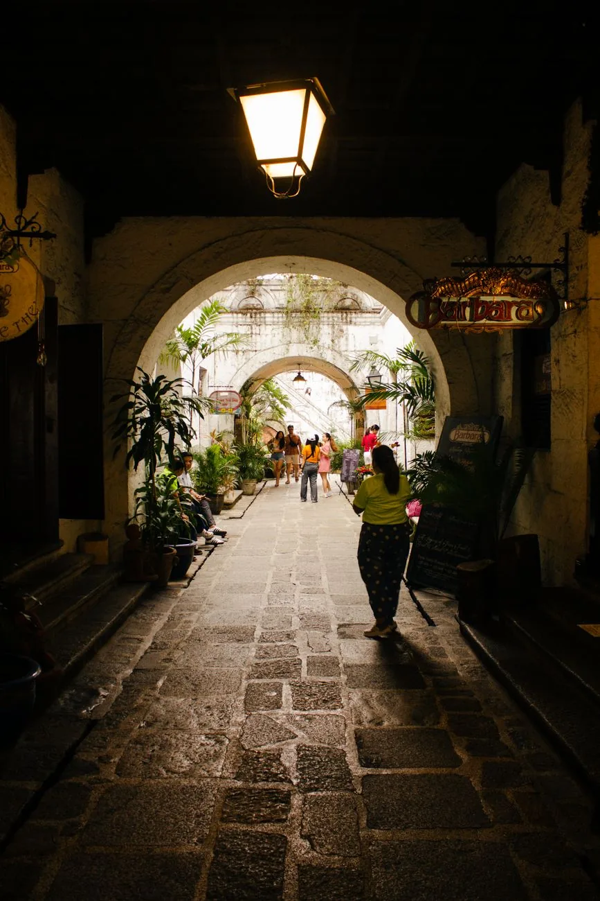 Stone-paved archway and planted passage at Casa Manila in Intramuros