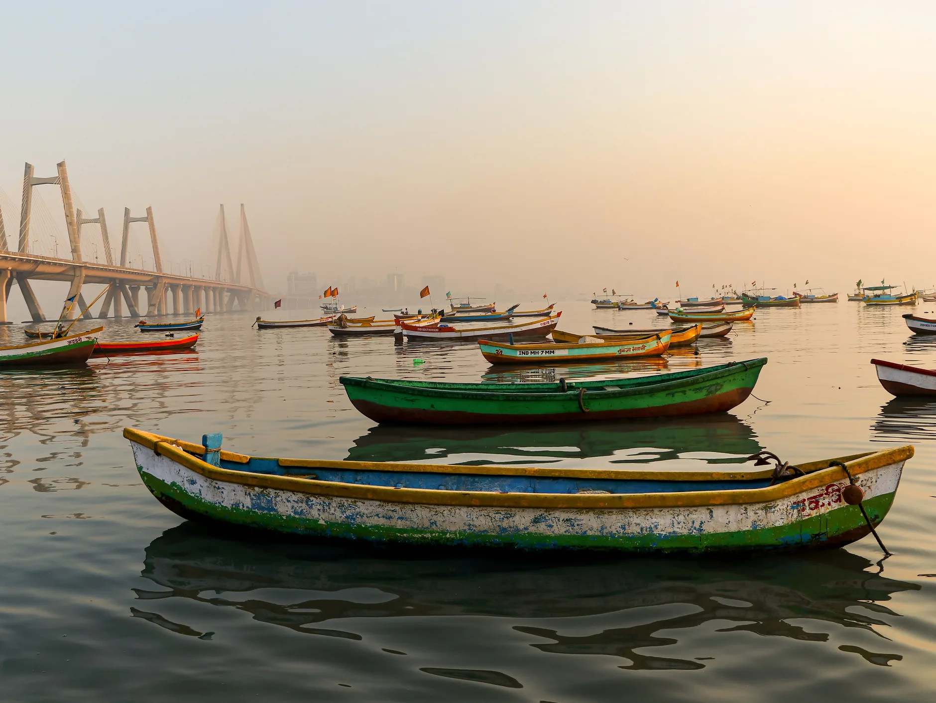 Colourful fishing boats at dawn beneath the Bandra–Worli Sea Link