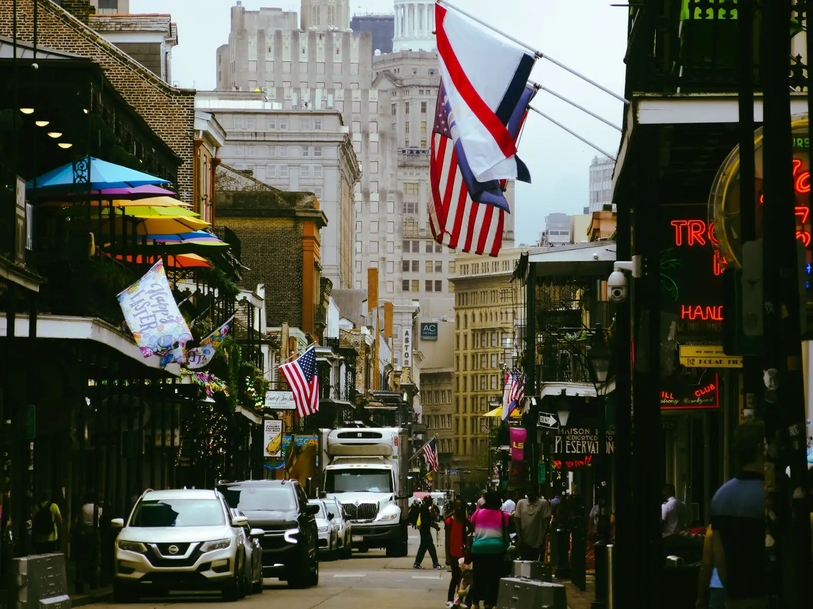 Bourbon Street in New Orleans with historic balconies, flags and recognisable local signs