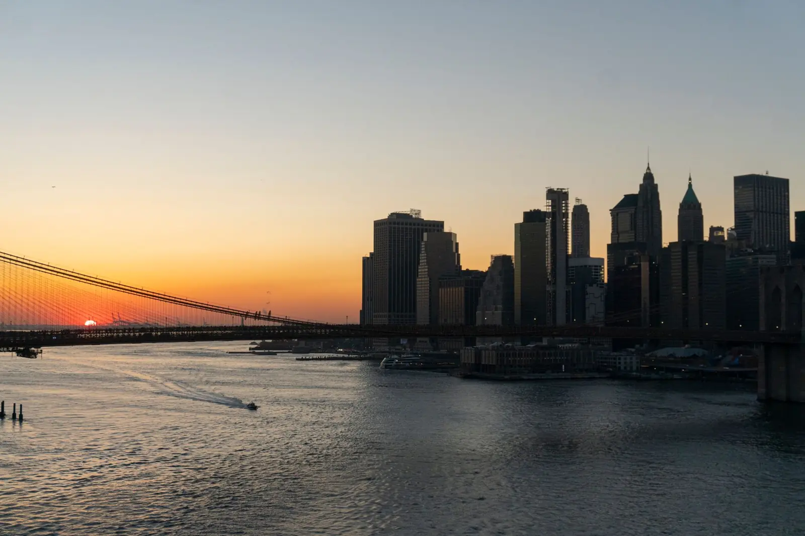 Brooklyn Bridge and Lower Manhattan skyline across the East River at sunset
