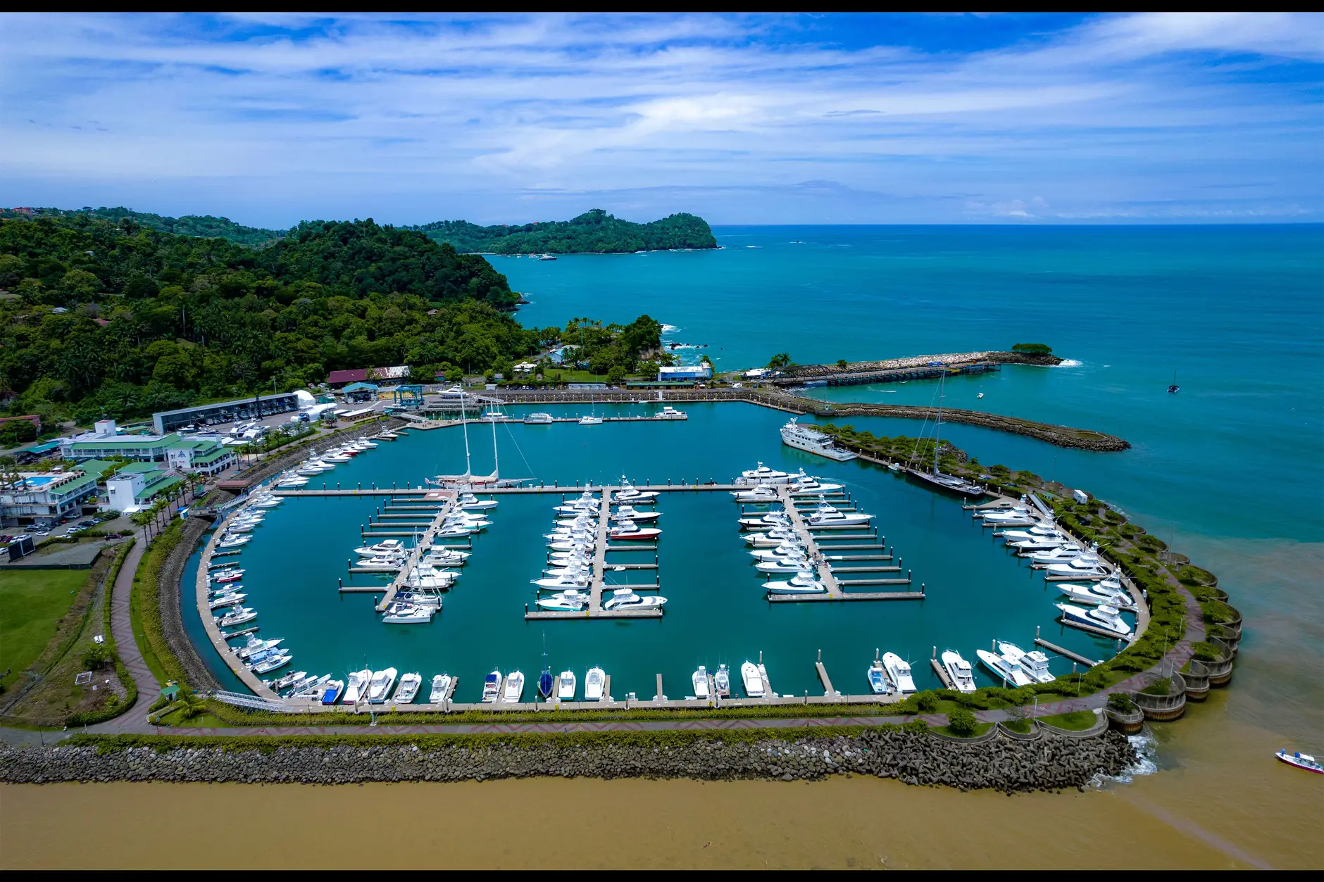 Boats and curved breakwaters at Marina Pez Vela in Quepos