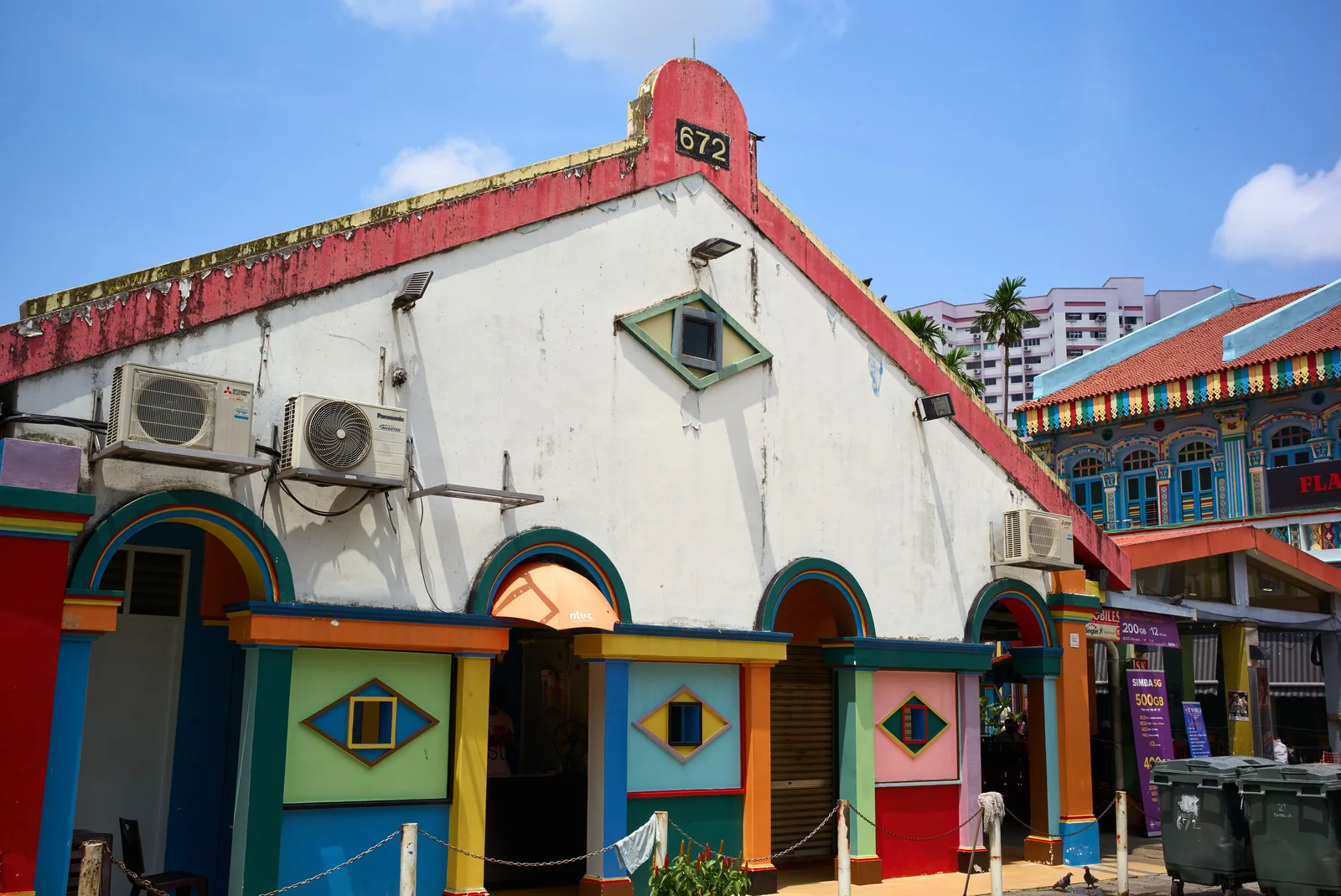 A colorful shophouse stands beside Singapore Little India’s painted street-fronts.