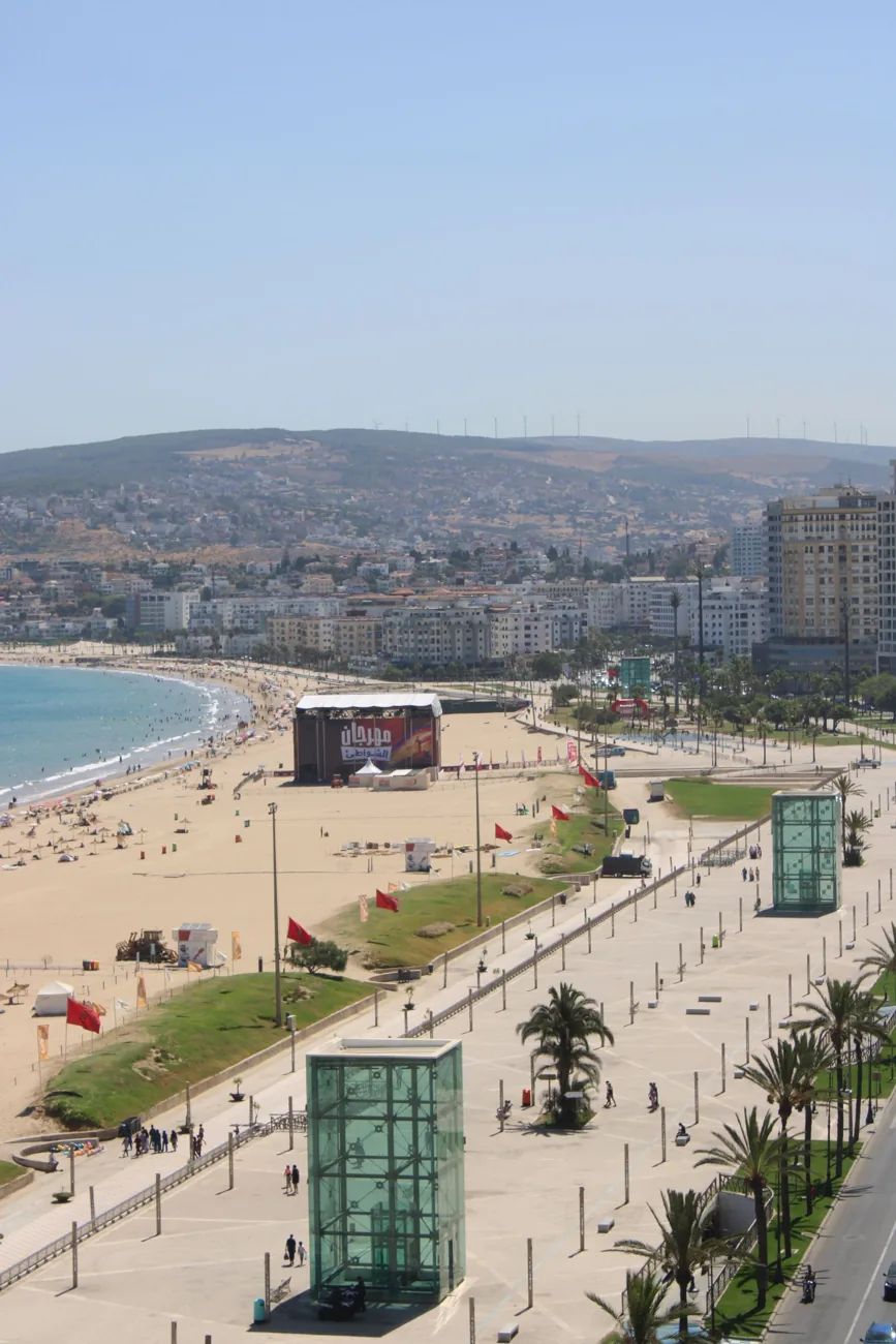 Tangier city beach and the broad corniche promenade with palms and glass access pavilions