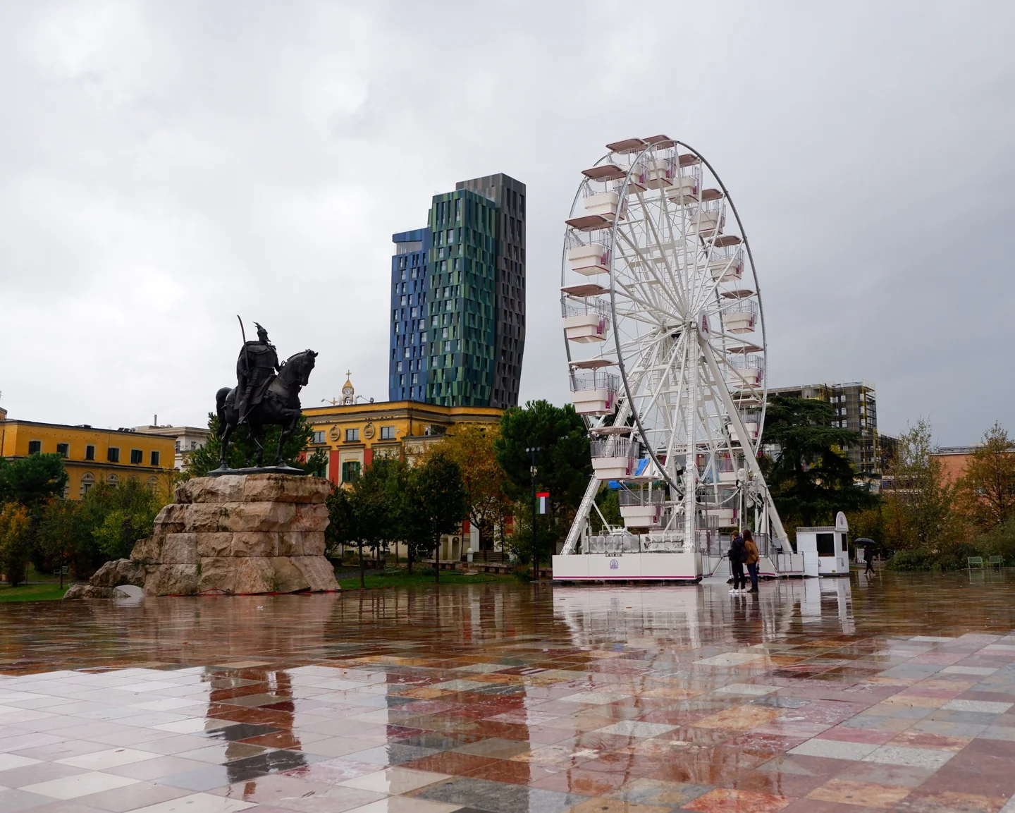 Skanderbeg monument in Tirana with a temporary Ferris wheel in the background