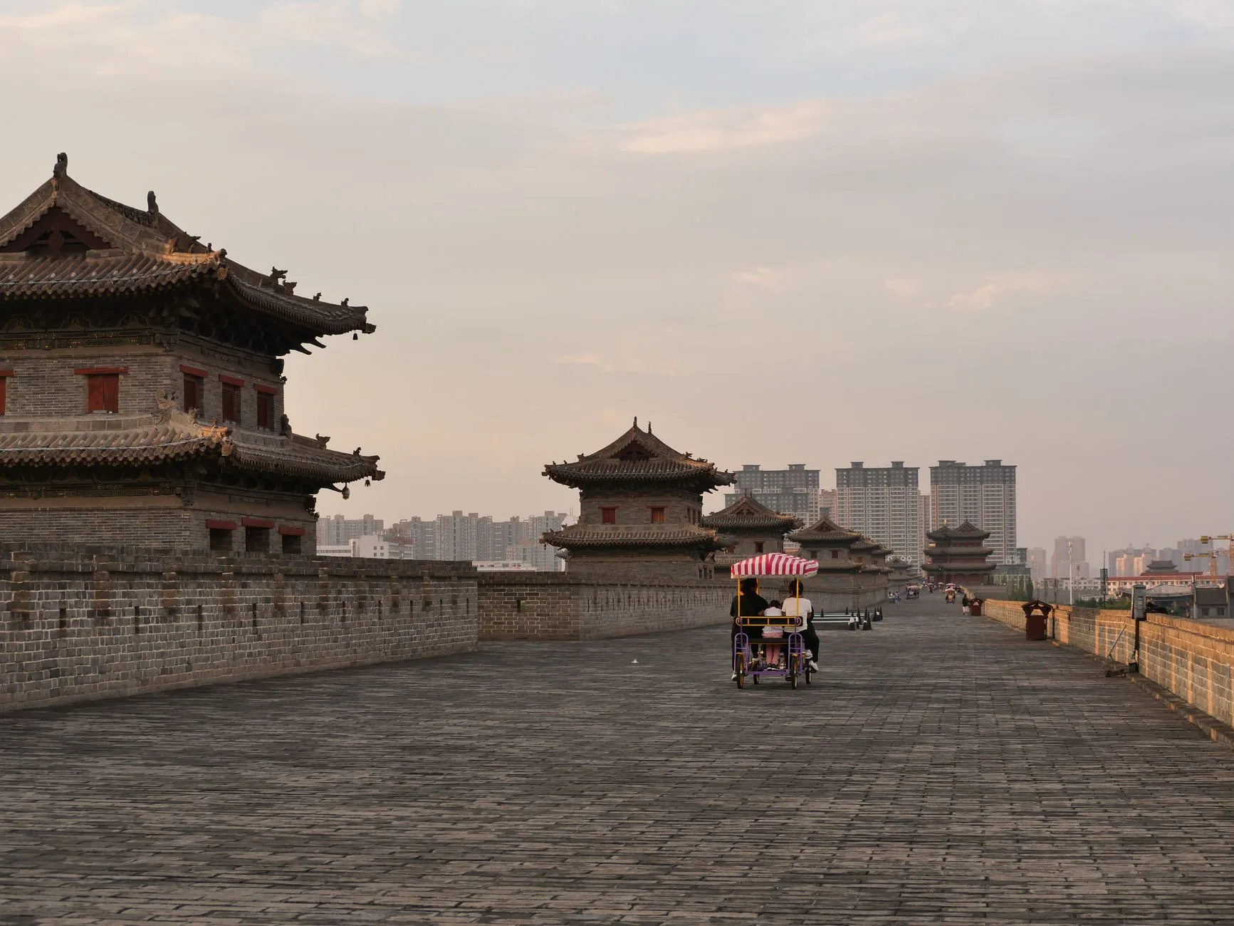 Broad brick walkway, watchtowers and cyclists on Xi’an City Wall