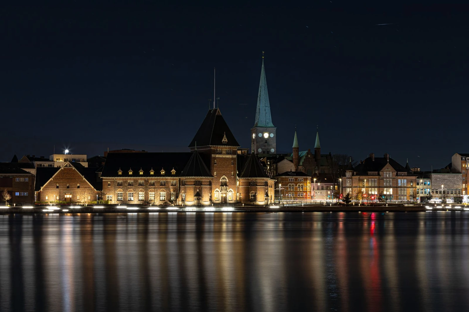 Aarhus Custom House and Cathedral illuminated beside the harbour at night