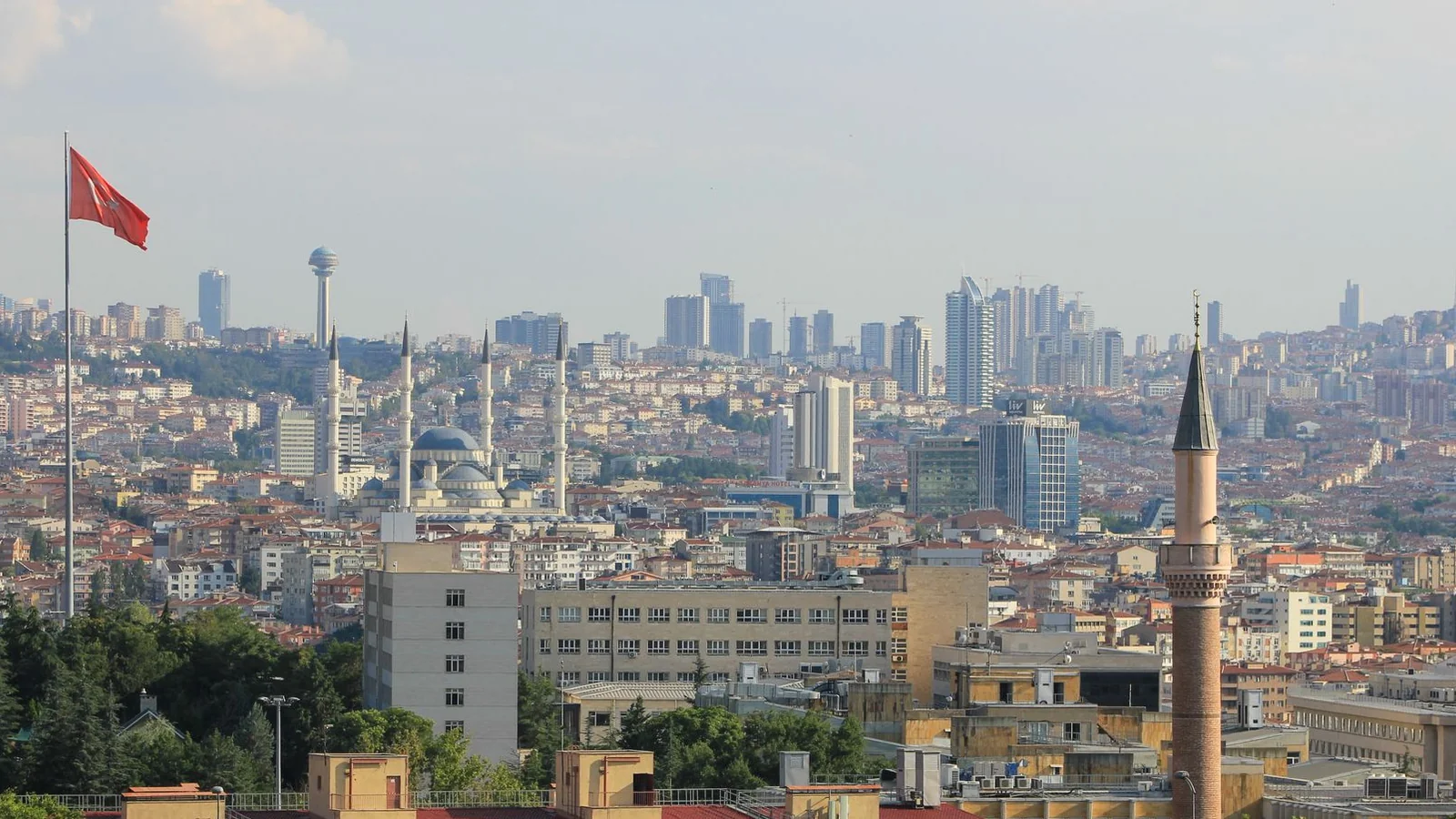 Ankara’s skyline with mosque domes, a foreground minaret and Atakule tower on the distant hillside.