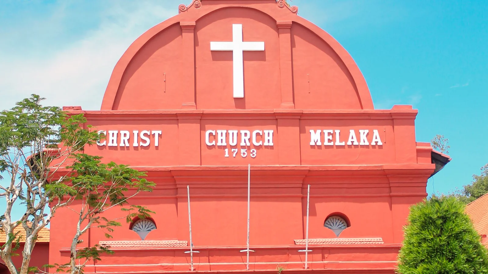 The red Christ Church Melaka facade with its white cross and lettering at Dutch Square.