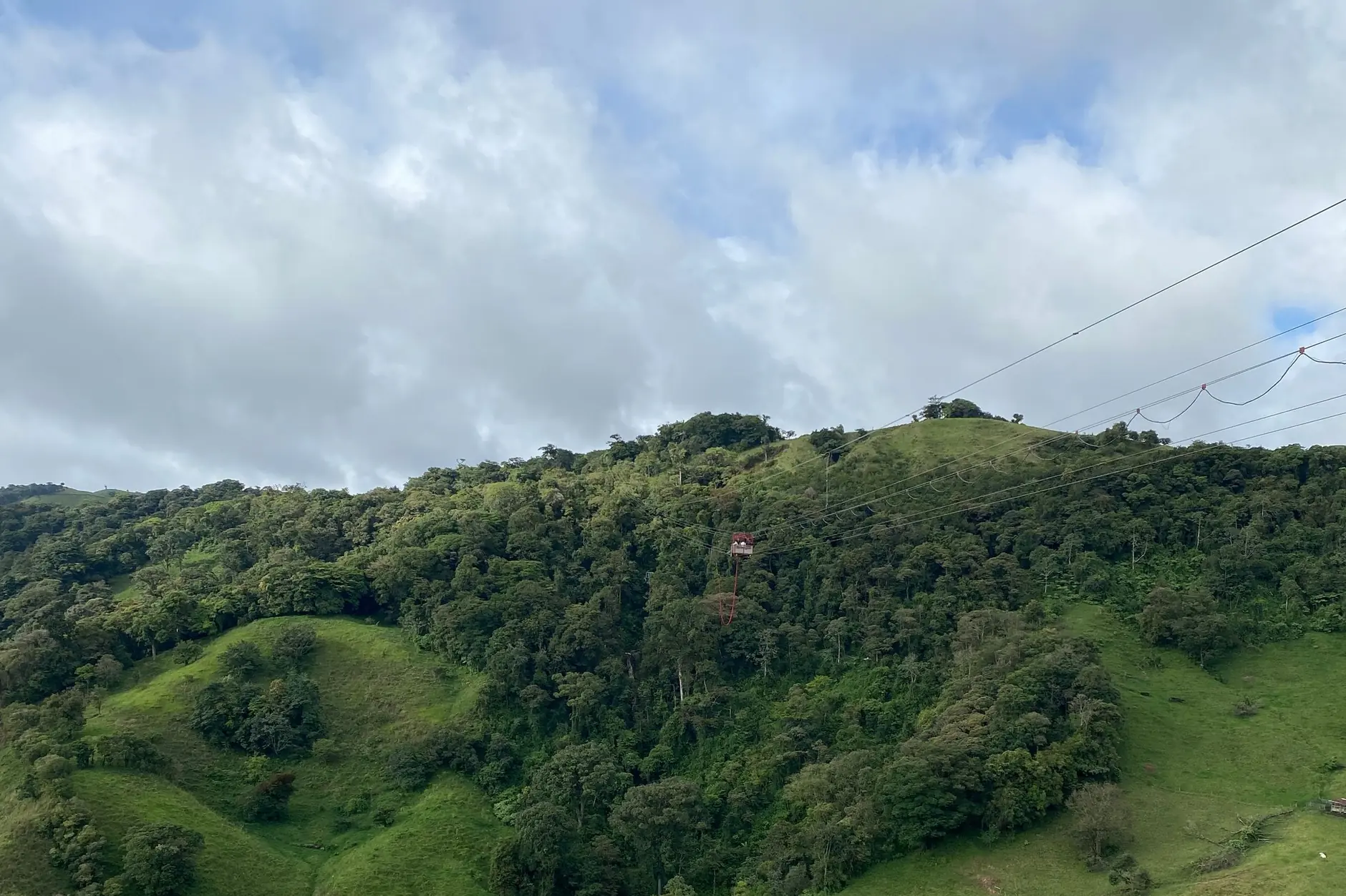 Green hills and a wooded ravine beneath a cloudy sky in Monteverde, Costa Rica
