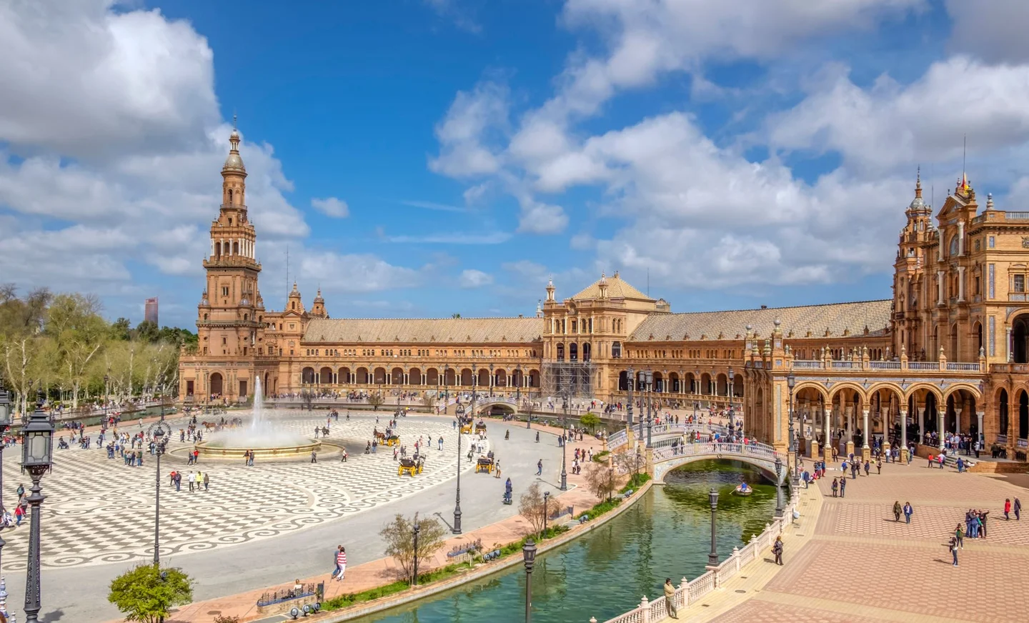 The bridges, canal and long tiled façade of Plaza de España in Seville